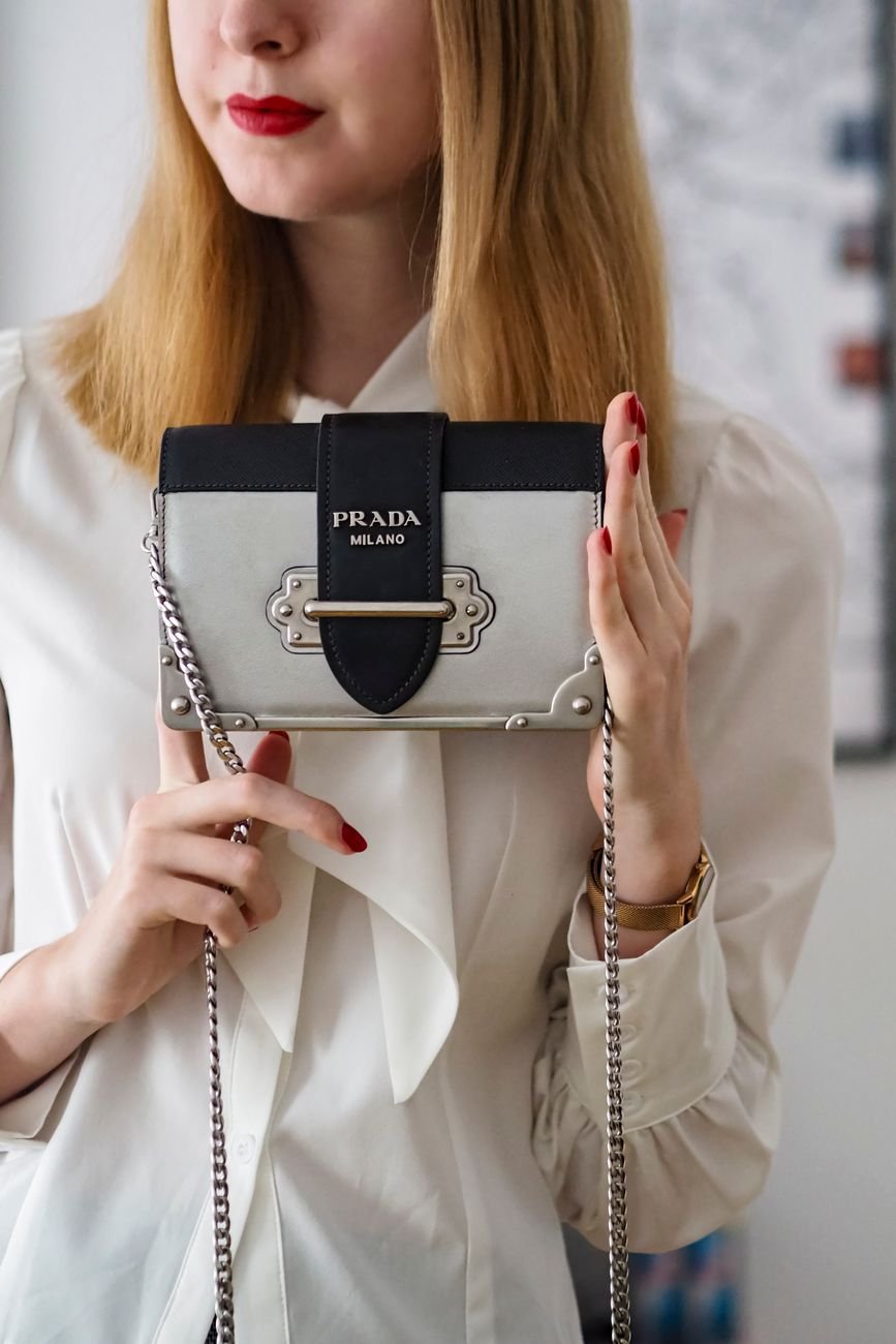 Elegant woman holding a stylish luxury handbag, highlighting refined fashion